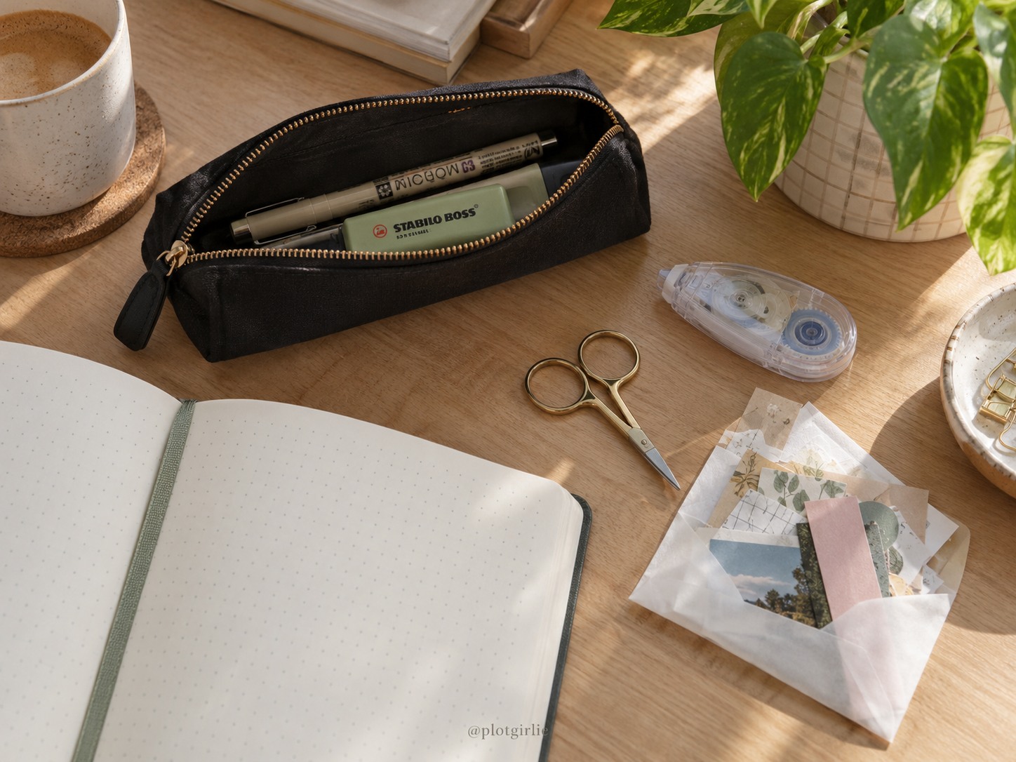 A small black stationery pouch, pen, highlighter, adhesive and envelope of paper scraps