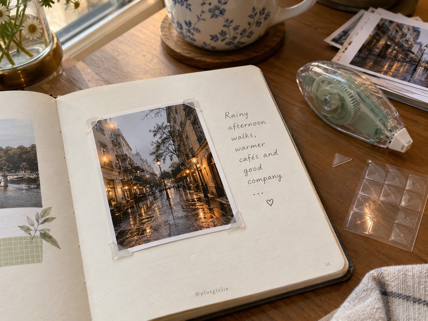 A rainy-street photograph held by clear photo corners in a journal beside an adhesive runner